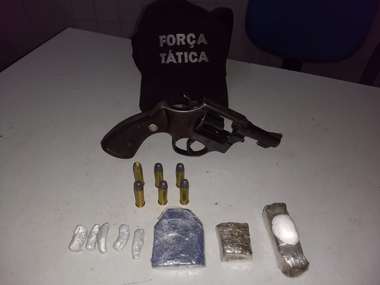 Com os suspeitos foram encontrados arma e drogas.